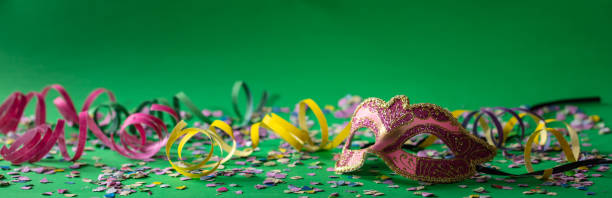 istock Carnival mask, streamers and confetti on bright green background 1071149140