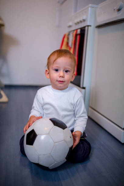 istock kid is playing with ball and crawling on the floor 1071149714