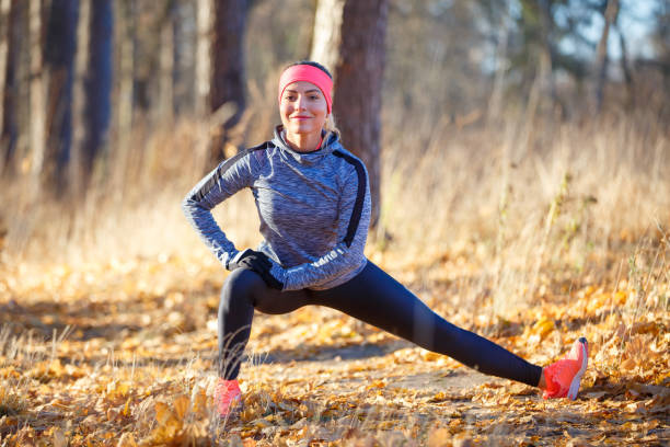 istock Young woman stretching before jogging in park 1071149744
