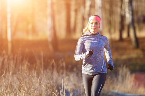 młoda dziewczyna biegająca w parku wczesną zimą - jogging off track running women running zdjęcia i obrazy z banku zdjęć