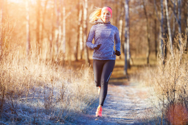 young girl running in the park in early winter - off track running imagens e fotografias de stock