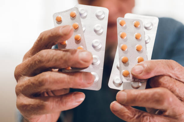 istock Elderly man holding pills 1071152070