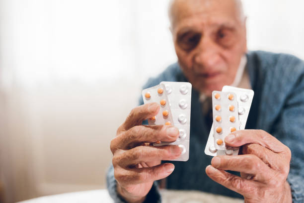 istock Elderly man holding pills 1071152156