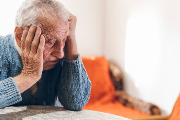 trauriger senior mann denken über das leben - alzheimer krankheit stock-fotos und bilder