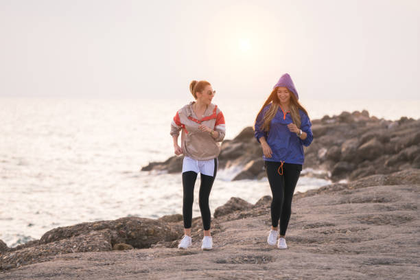 istock Two happy women exercise by the sea 1071153876
