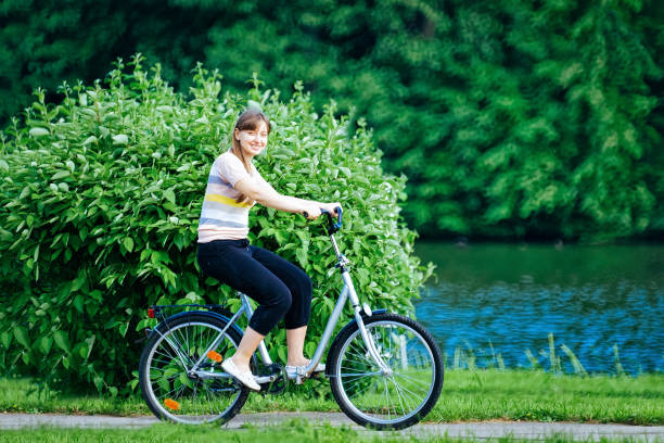 istock Young lady riding bicycle at park in Voronovo 1071153912