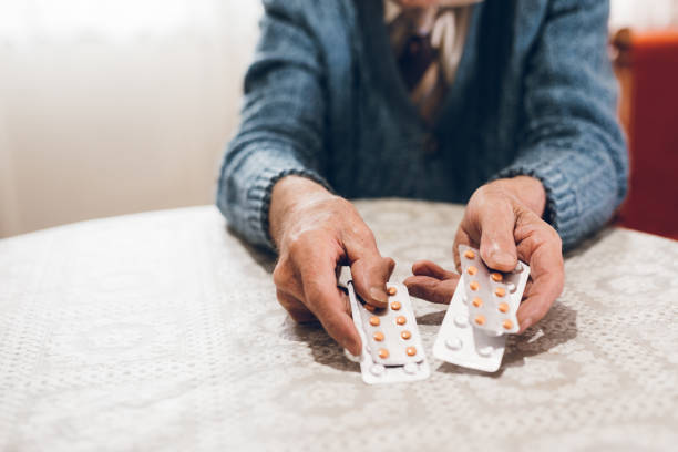istock Elderly man holding pills 1071154104