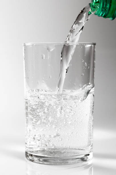 istock Pouring clear water into glass. Isolated on white background. 1071154392
