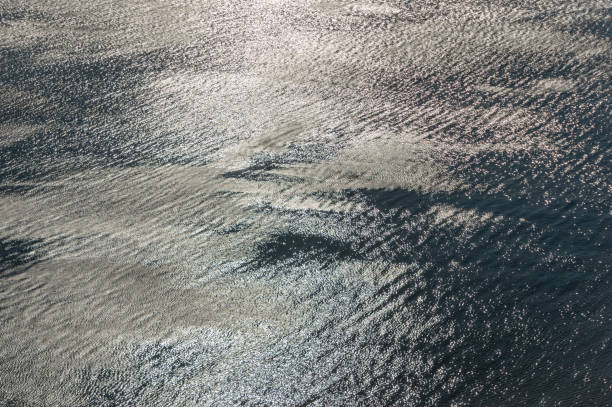 istock Strong sunlight reflection on blue sea surface. Nature texture and background with silver effect. 1071164536