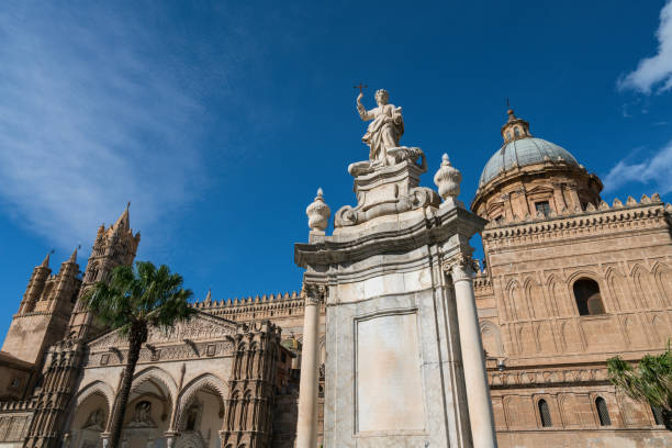 View towards The Metropolitan Cathedral of the Assumption of Virgin Mary of Palermo. Cloudless blue sky can be seen in the background. As an architectural complex, it is characterized by the presence of different styles, due to a long history of additions, alterations and restorations