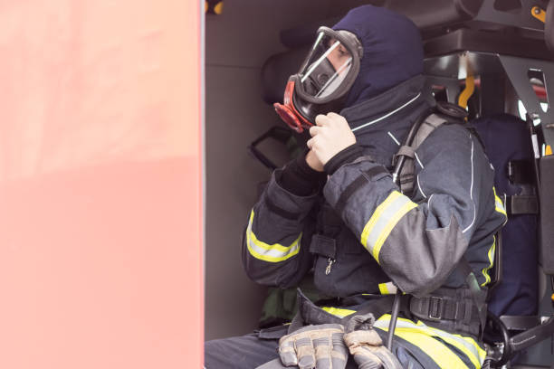 istock Firefighter with a gas mask sitting in a fire truck 1071177334