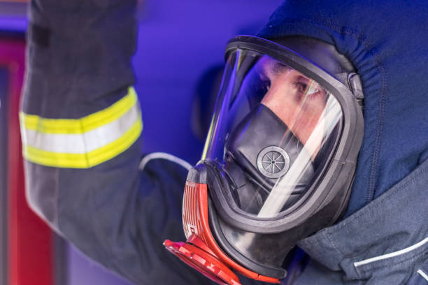istock Firefighter with a gas mask sitting in a fire truck 1071180650