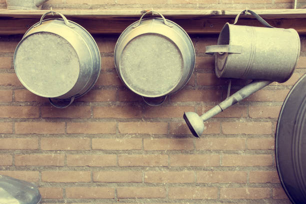 istock Metal Watering Cans by Brick Wall in garden 1071180662