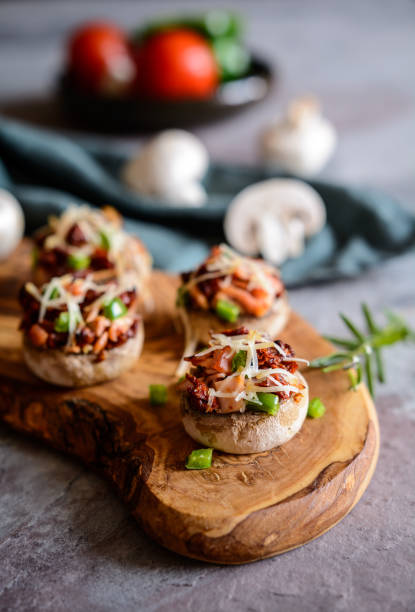 funghi arrostiti ripieni di prosciutto, pomodoro essiccato al sole e peperone - antipasto roasted pepper bell pepper pepper foto e immagini stock