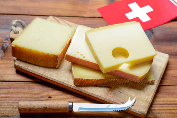 assortment of swiss cheeses emmental or emmentaler medium-hard cheese with round holes, gruyere, appenzeller and raclette used for traditional cheese fondue and gratin and flag of switzerland - cheese emmental cheese switzerland grated imagens e fotografias de stock