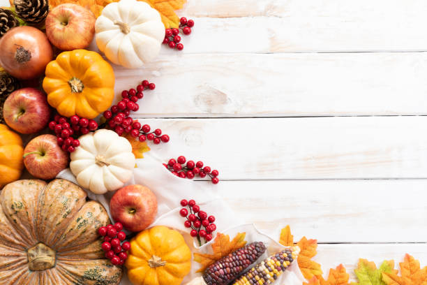 bovenaanzicht van autumn maple laat met pompoen en rode bessen op witte houten achtergrond. thanksgiving day concept. - pronkstuk stockfoto's en -beelden