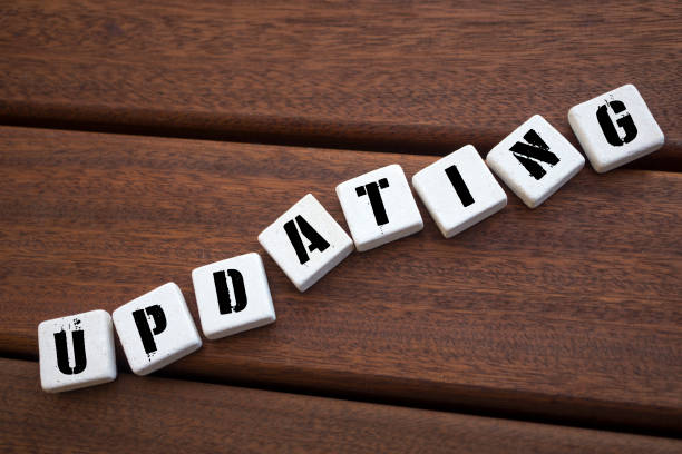 istock UPDATING Concept with alphabet blocks on wooden table. 1071206248