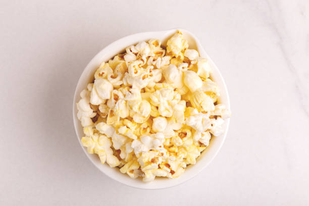 istock Tasty salty popcorn in bowl on light marble background. 1071217634