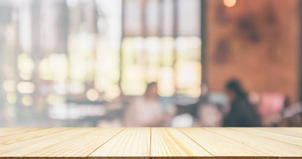 istock Empty Wood table top with Restaurant cafe or coffee shop interior with customer blur abstract vintage style bokeh light for montage product display background 1071220522