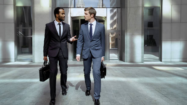 istock Business partners leaving office center, discussing successful cooperation 1071225320