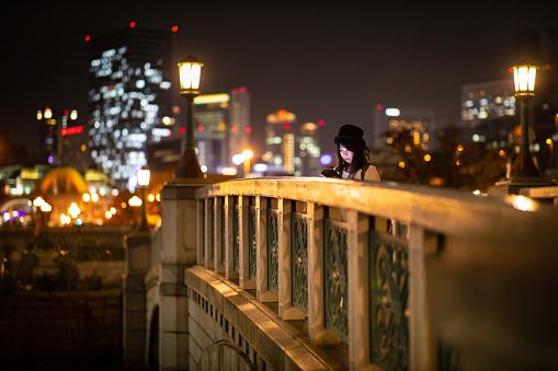 Woman using digital tablet in illuminated night city