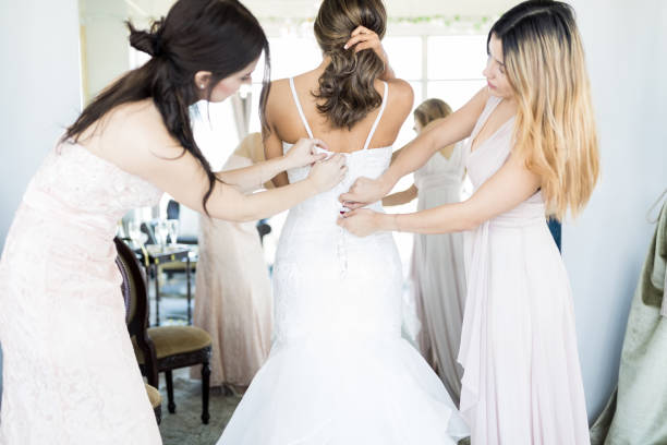 istock Bridesmaids Assisting Bride In Getting Ready 1071239660