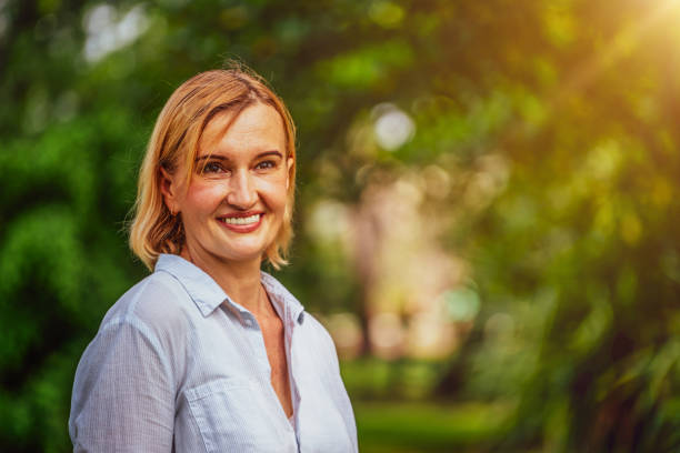 istock Happy middle aged woman standing in the park. 1071249018