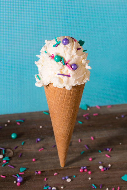 istock Vanilla Ice Cream in a Sugar Cone on a Blue Background 1071249060