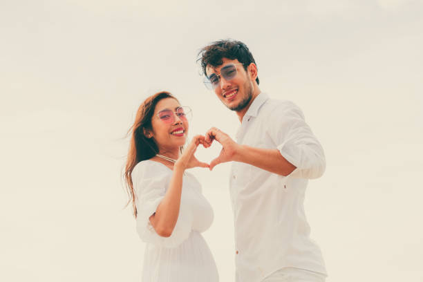 istock Young couple shows heart shape hand gesture. 1071249466