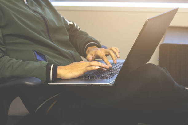 istock Young man sitting  on the chair using a laptop and typing keyboard . 1071257890