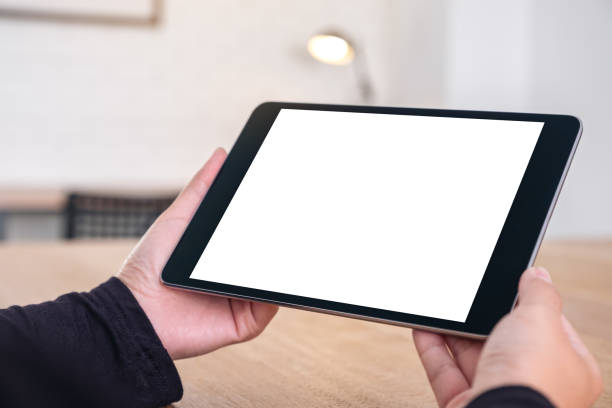 istock Mockup image of hands holding black tablet pc with blank white screen while sitting in office 1071259762