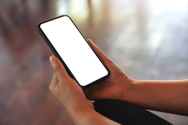 istock Mockup image of hands holding black mobile phone with blank white screen 1071260260