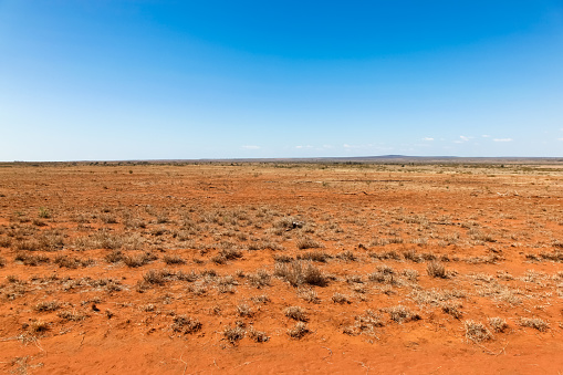 Flat orange drought effected land in central Queensland south of Charters Towers. Central Queensland is a remote place and subject to many droughts.