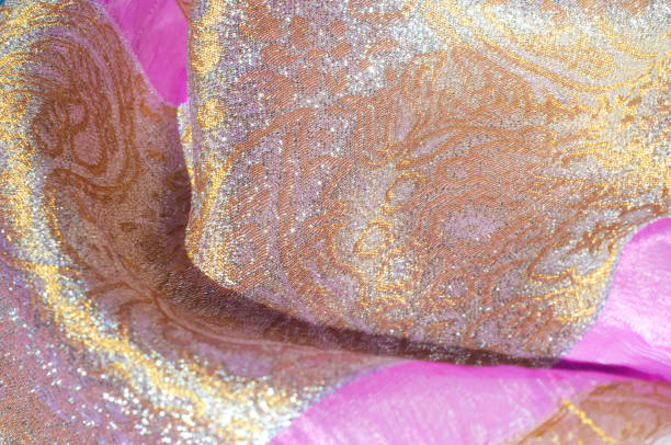 istock Texture, background, pattern. Combined silk white fabric and gold and silver damask fabric, pink ribbons 1071273364
