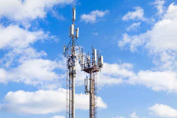 istock Two cell towers against the blue sky with clouds. Mobile communications and communications. 1071280210