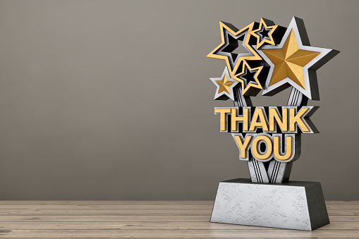 Award Trophy with Golden Thank You Sign on a wooden table. 3d Rendering