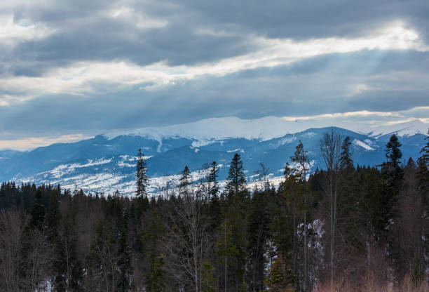 istock Evening winter mountain ridge and sun rays from cloudy sky 1071296842