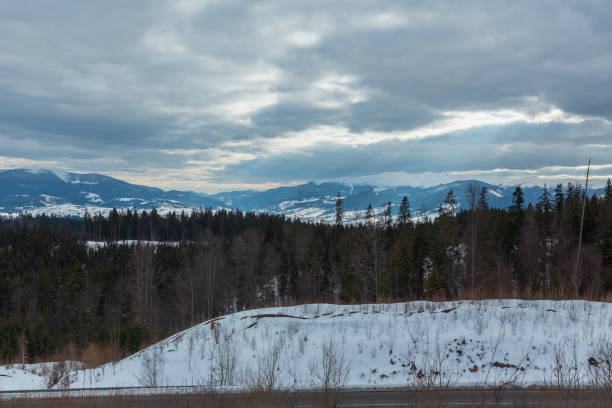 istock Evening winter mountain ridge and sun rays from cloudy sky 1071297028