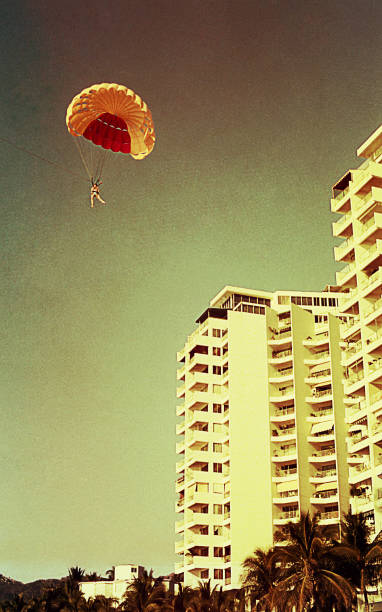 Vintage parachuting in Acapulco in the seventies Vintage image of a mother and her children during a summer vacation in the seventies / eighties. 1980 photos stock pictures, royalty-free photos & images