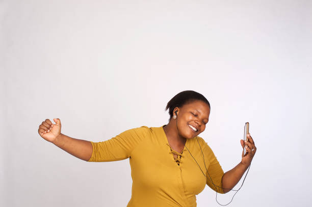 hermosa mujer africana bailando al ritmo de la música - deep etch fotografías e imágenes de stock