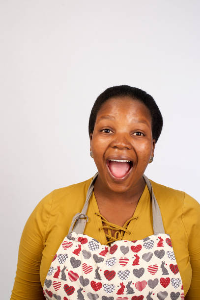 hermosa mujer africana con delantal riendo con la boca abierta - deep etch fotografías e imágenes de stock