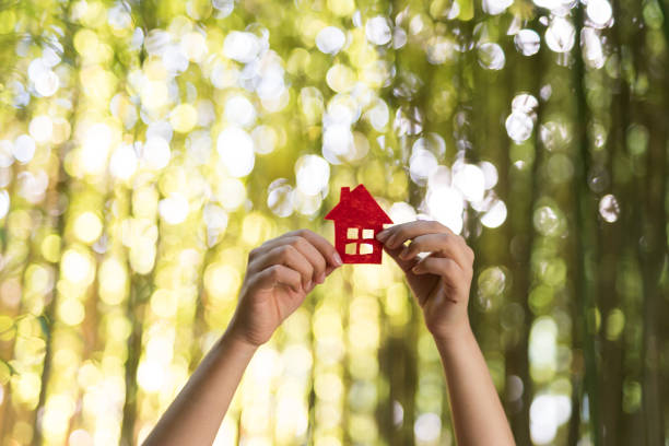 istock Paper house in hand outdoor 1071307612