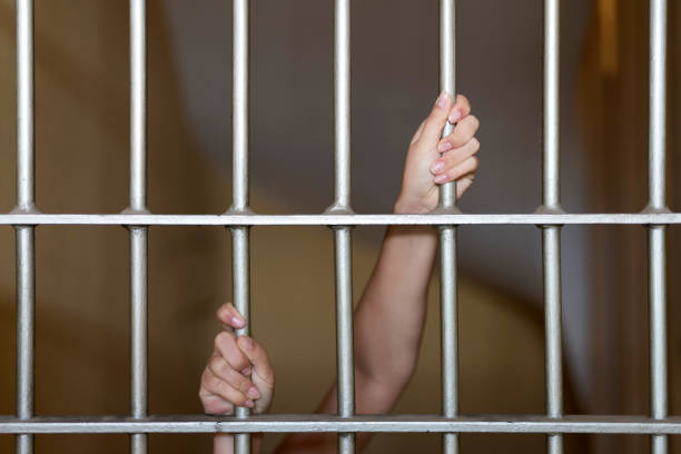 istock Hands of a prisoner on prison bars 1071307734