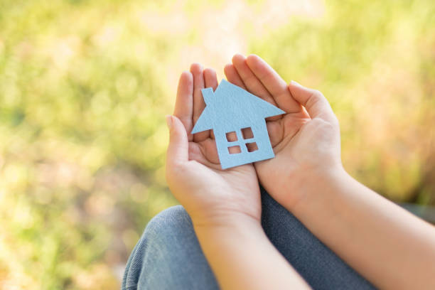 istock Paper house in hand outdoor 1071307736