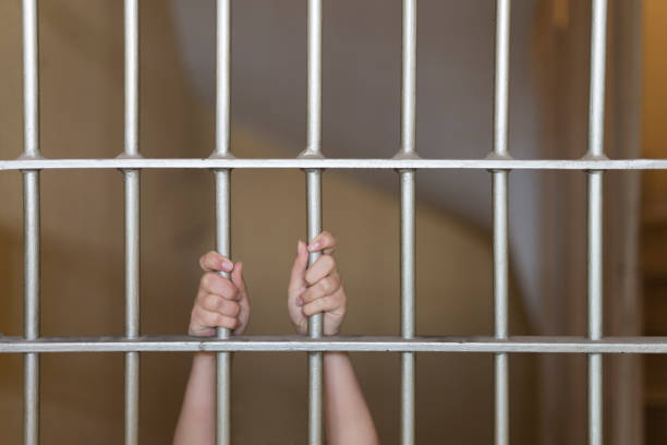 istock Hands of a prisoner on prison bars 1071307778