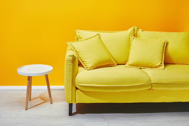 istock Yellow sofa and white coffee table near bright wall 1071308776