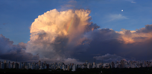 After a heavy rain at a residential district in São Paulo, Brazil, the sky turns blue and a small rainbow can be seen on a beautiful sunset cloud formation