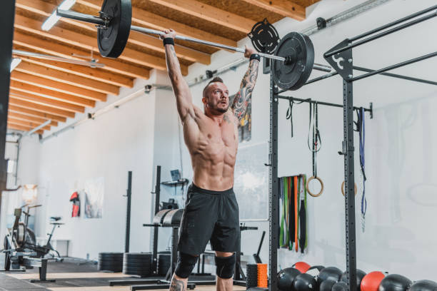 Man doing a clean and jerk at the gym Man doing a clean and jerk at the gym clean and jerk stock pictures, royalty-free photos & images