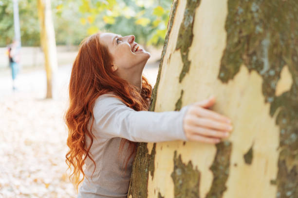 istock Happy young woman hugging a large tree 1071320360
