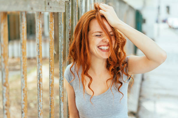 Woman with hair and grey shirt pulling her hair stock photo